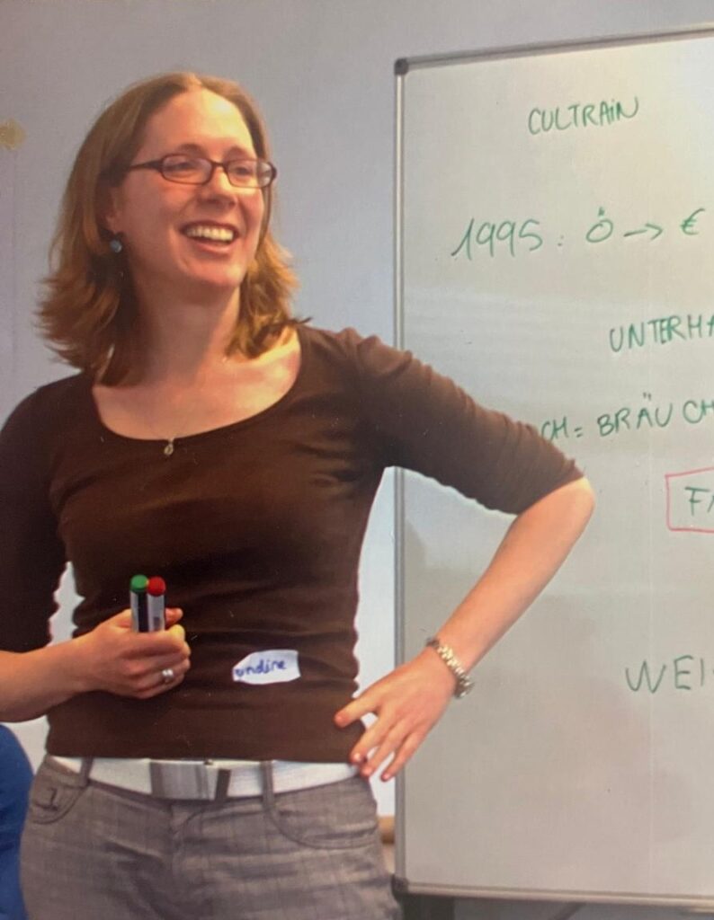 Ondine Delavelle steht 2016 lächelnd vor einem Whiteboard und erklärt Inhalte während eines Workshops.